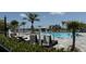 Beautiful community swimming pool with lounge chairs, umbrellas, and swaying palm trees at 15963 Crofton Springs Way, Port Charlotte, FL 33953
