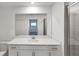 Bright bathroom featuring a large mirror, white cabinets, and modern fixtures at 17595 Opal Sand Dr # 205, Venice, FL 34293