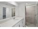 Bathroom featuring white cabinets, a vanity, a sink, and a stand-up shower at 17595 Opal Sand Dr # 205, Venice, FL 34293