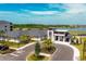 A modern clubhouse with a pro shop, surrounded by lush landscaping and a view of the lake and golf course at 17595 Opal Sand Dr # 205, Venice, FL 34293
