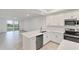 Open concept kitchen with stainless steel appliances and an adjacent living area with glass doors at 17595 Opal Sand Dr # 205, Venice, FL 34293