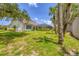 Expansive backyard featuring mature trees, a lawn, and an enclosed screened-in patio at 188 Grand Oak Cir, Venice, FL 34292