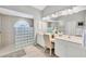 Bright bathroom with a glass block shower, double sink vanity, and ample counter space at 188 Grand Oak Cir, Venice, FL 34292