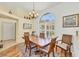 Elegant dining room features a wood table, chandelier, and large arched window with bright natural light at 188 Grand Oak Cir, Venice, FL 34292