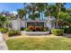 Community entrance sign with lush landscaping and mature palm trees at 188 Grand Oak Cir, Venice, FL 34292