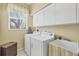 Laundry room with washer, dryer, storage cabinets, and a sink at 188 Grand Oak Cir, Venice, FL 34292
