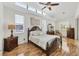 Cozy main bedroom features a dark wood bed frame, hardwood floors, and ample natural light at 188 Grand Oak Cir, Venice, FL 34292