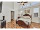 Comfortable main bedroom boasts hardwood floors, a ceiling fan, and large windows at 188 Grand Oak Cir, Venice, FL 34292