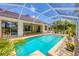 Screened-in pool with a tiled deck and tropical landscaping at 188 Grand Oak Cir, Venice, FL 34292