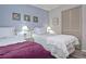A bedroom with twin beds, coastal wall art, and light blue walls at 200 The Esplanade N # C19, Venice, FL 34285