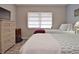 Comfortable bedroom featuring twin beds, a window with blinds, and wicker furniture at 200 The Esplanade N # C19, Venice, FL 34285