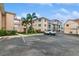 Attractive building exterior with manicured landscaping, mature palm trees, and convenient parking at 200 The Esplanade N # C19, Venice, FL 34285