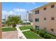 Well-maintained building exterior with manicured lawn, palm trees, and neatly trimmed hedges at 200 The Esplanade N # C19, Venice, FL 34285