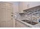 Clean kitchen features granite countertops, stainless steel sink, stylish backsplash, and shaker cabinets at 200 The Esplanade N # C19, Venice, FL 34285