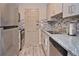 Charming kitchen features stainless steel appliances, granite countertops, modern backsplash, and ample cabinets at 200 The Esplanade N # C19, Venice, FL 34285
