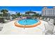 A circular pool surrounded by lounge chairs and tropical plants at 200 The Esplanade N # C19, Venice, FL 34285