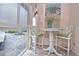 Enclosed porch with two chairs, table and pleasant natural light from the surrounding windows and open view at 200 The Esplanade N # C19, Venice, FL 34285