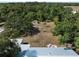 Aerial view showcases the metal roof of the home and surrounding wooded landscape, plus outdoor seating area at 2008 55Th E Ave, Bradenton, FL 34203