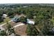 Wide aerial shot showcases the home's layout, neighboring houses, and lush wooded surroundings in the distance at 2008 55Th E Ave, Bradenton, FL 34203