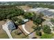 Aerial view highlighting a home's wooded lot, driveway, and proximity to surrounding neighborhood and school at 2008 55Th E Ave, Bradenton, FL 34203