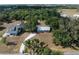 Aerial view of a home and its surroundings, including a white gravel driveway and mature tree coverage at 2008 55Th E Ave, Bradenton, FL 34203