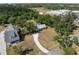 Aerial view of a home and its surrounding lot, next to wooded area, a driveway, and neighboring homes at 2008 55Th E Ave, Bradenton, FL 34203