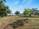 Large backyard with a single-story home, an outdoor patio, and mature trees on the property at 2008 55Th E Ave, Bradenton, FL 34203