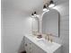 Bright bathroom featuring a dual sink vanity with bronze fixtures, framed mirrors and a shiplap accent wall at 2008 55Th E Ave, Bradenton, FL 34203