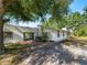 Charming single-story home featuring updated siding, dark trim windows, an attached carport and lush landscaping at 2008 55Th E Ave, Bradenton, FL 34203