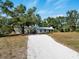 Charming single story home with white gravel drive and mature shade trees on a sunny day at 2008 55Th E Ave, Bradenton, FL 34203