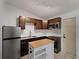 Close-up of updated kitchen with stainless steel appliances and butcher block island at 2008 55Th E Ave, Bradenton, FL 34203