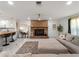 Cozy living room showcasing a brick fireplace, ceiling fan, and seamless flow into the kitchen at 2008 55Th E Ave, Bradenton, FL 34203