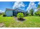 The lush, green backyard features a screened in lanai with beautiful tropical landscaping at 20235 Granlago Dr, Venice, FL 34293
