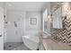 This contemporary bathroom features a soaking tub, glass shower, and double vanity at 20235 Granlago Dr, Venice, FL 34293