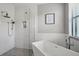 Modern bathroom features a soaking tub and frameless glass shower, complemented by elegant fixtures and neutral decor at 20235 Granlago Dr, Venice, FL 34293