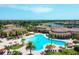 Expansive community pool area with palm trees, umbrellas, sun loungers, and the clubhouse in a beautiful setting at 20235 Granlago Dr, Venice, FL 34293