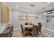This lovely dining room has a modern chandelier and gray upholstered chairs at 20235 Granlago Dr, Venice, FL 34293