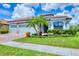 Charming single-story home featuring a three-car garage, well-manicured lawn, and lush tropical landscaping at 20235 Granlago Dr, Venice, FL 34293