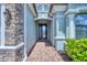 Elegant entryway featuring a decorative glass front door, stone accents, and covered porch at 20235 Granlago Dr, Venice, FL 34293