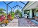 The screened lanai has brick pavers, a grill, and several potted plants creating a peaceful outdoor space at 20235 Granlago Dr, Venice, FL 34293