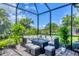 The covered lanai features comfortable seating around a gas fire pit, perfect for outdoor entertaining at 20235 Granlago Dr, Venice, FL 34293