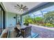 Outdoor living space on screened lanai with brick pavers, ceiling fan, and tropical landscaping at 20235 Granlago Dr, Venice, FL 34293