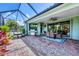 Spacious screened lanai with brick pavers, grill, seating area, and sliding doors to the living area at 20235 Granlago Dr, Venice, FL 34293