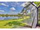 Palm-lined backyard offers serene lake views from the screened lanai at 213 Malina Ct, Nokomis, FL 34275