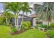 A screened patio and lush tropical landscaping make for a relaxing outdoor space with stone bench at 213 Malina Ct, Nokomis, FL 34275