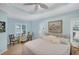 Tranquil bedroom with blue walls, tray ceiling, and shuttered windows at 213 Malina Ct, Nokomis, FL 34275