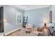Bright bedroom with a cozy chair, plantation shutters, and neutral decor at 213 Malina Ct, Nokomis, FL 34275