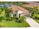 Aerial view showcasing a well-maintained home featuring a tile roof and lush landscaping near a pond at 213 Malina Ct, Nokomis, FL 34275