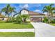 Beautiful single-story home featuring a tile roof, palm trees, and a well-maintained lawn at 213 Malina Ct, Nokomis, FL 34275