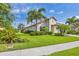 Exterior view of a well-manicured lawn and landscaping around a tile-roofed home at 213 Malina Ct, Nokomis, FL 34275